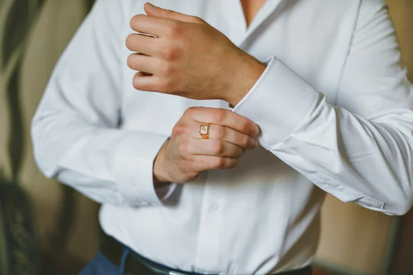 Primer plano de un hombre de la mano cómo lleva camisa blanca y gemelo — Foto de Stock