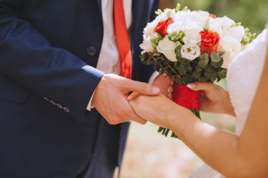 Yeni evliler, elinde gelin buketi kırmızı beyaz çiçekler