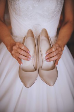 Klasik bej ayakkabı, kız, arka plan beyaz elbise elinde