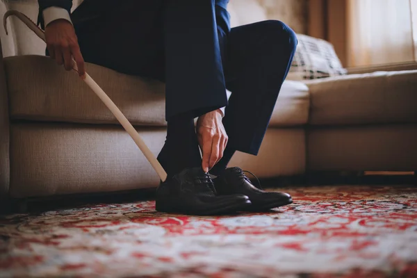 Hombres con botas negras de trabajo. sentado en el sofá en un traje azul —  Fotos de Stock