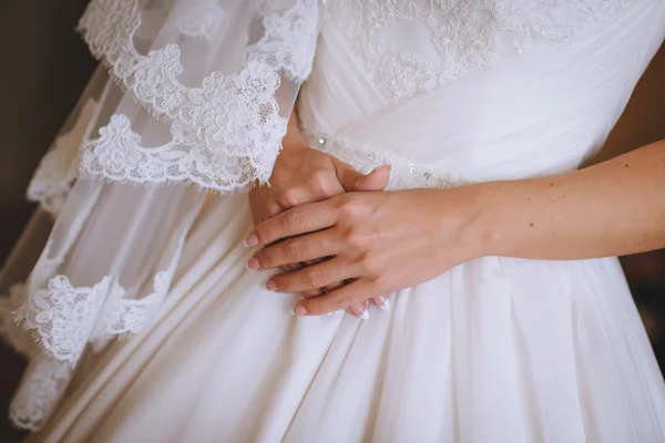 Hermosas manos de la novia en el vestido de encaje blanco de la boda — Foto de Stock