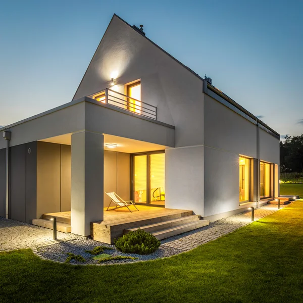 Extérieur de la maison illuminée parmi le vert — Photo