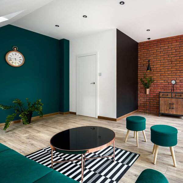 Стильная гостиная с двумя декоративными стенами, одна в красном брике, а другая в изумрудно-зеленом