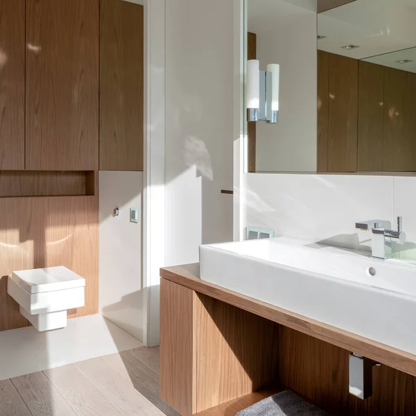 简单的浴室 有长盆 正方形厕所 木制家具和木制地砖 — 图库照片