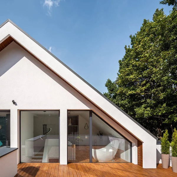 Attic balcony with wooden floor in elegant house with white facade