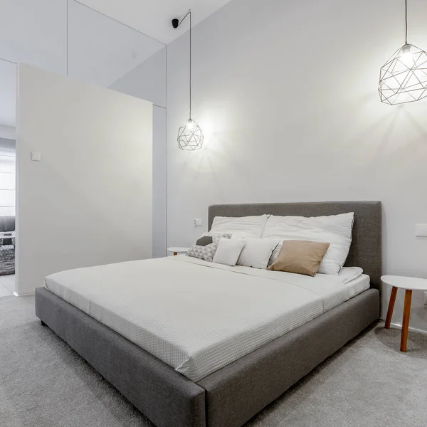 グレーと大きく快適なベッド ペンダントランプと明るい白い寝室で張りのフレーム — ストック写真