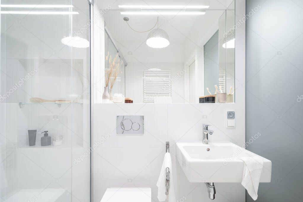 Simple white bathroom with shower, big mirror, classic washbasin and wall from frosted glass