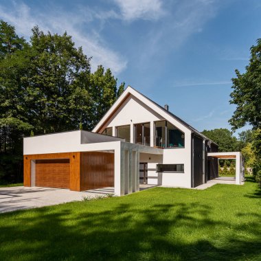 Dikkate değer, yeşil bahçeli ve ağaçlı beyaz evin dış görünüşü