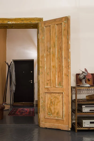 Amazing old wooden doors open to simple corridor in stylish tenement apartment