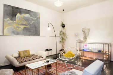 Yaratıcı dekorasyonları, sanat eserleri ve klasik mobilyalarıyla oturma odasında sanatsal ve eşsiz bir tasarım.
