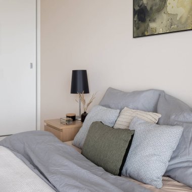 Rahat yatak odasındaki rahat, gri, bej ve yeşil yastıklara yakın çekim