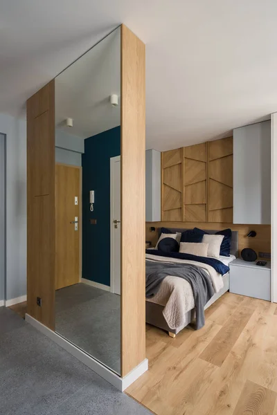 格调典雅的卧室 大而舒适的床 在木制墙壁后面有镜子装饰床上用品 — 图库照片