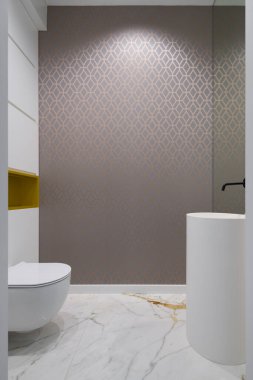 Stylish lavatory with marble floor,patterned wallpaper, modern washbasin with black tap and toilet