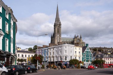 Arkasında renkli binalar ve St. Colman Katedrali olan İrlanda 'daki Cobh şehri manzarası