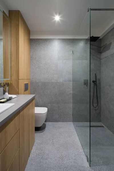 现代化的 简单的浴室 带有灰色 地板和墙壁上的花岗岩瓦 木制橱柜和玻璃墙后面的大淋浴房 — 图库照片