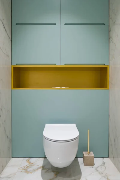浴室里的白色厕所 地板上有大理石瓷砖 墙壁和蓝色橱柜上有金架子 — 图库照片