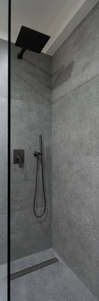 现代淋浴区的垂直全景 墙壁和地板上有玻璃墙和花岗岩瓦 有黑色水龙头 — 图库照片