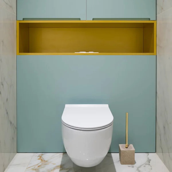 浴室白色厕所的特写镜头 地面上有大理石瓷砖 墙壁上有蓝色墙壁 还有金架子 — 图库照片
