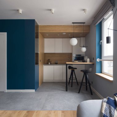 Küçük, modern ve küçük mutfak beyaz dolaplar, ahşap duvar, masa ve büyük pencere.