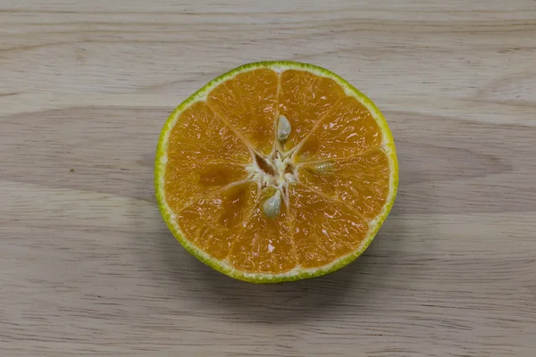 Naranja cortada sobre fondo de madera — Foto de Stock