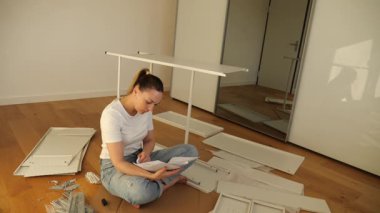 Evdeki aletler, vidalar ve kullanma kılavuzuyla insan yapımı dolabı gösteren düz paket mobilyaların adım adım nasıl monte edileceği. Yeni başlayanlar için kolay öğretici