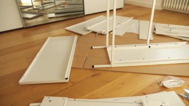 Ahşap zemine mobilya montaj aletleri ve donanım döşenmiş. DIY kurulumdan önce gösterilen vidalar, parantezler, çekmece slaytları, paneller ve tornavidalar. Ev geliştirme görselleri için ideal