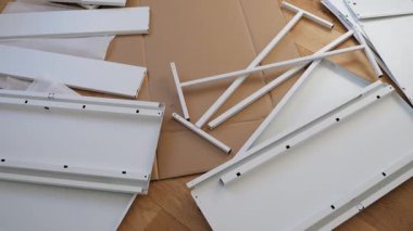 Ahşap zemine mobilya montaj aletleri ve donanım döşenmiş. DIY kurulumdan önce gösterilen vidalar, parantezler, çekmece slaytları, paneller ve tornavidalar. Ev geliştirme görselleri için ideal