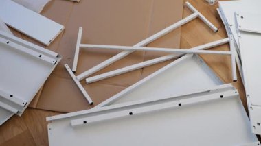 Ahşap zemine mobilya montaj aletleri ve donanım döşenmiş. DIY kurulumdan önce gösterilen vidalar, parantezler, çekmece slaytları, paneller ve tornavidalar. Ev geliştirme görselleri için ideal