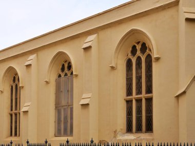 Malta Valletta 'da yeşil, ahşap panjurlu ve süslü pencere kemerli tarihi bir kireçtaşı bina cephesi..