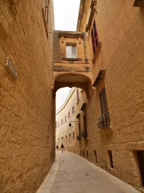 Mdina, Malta 'da geleneksel bal renkli kireç taşı binalar arasında dar bir geçit var. Bu pitoresk, sessiz sokak tarihi 