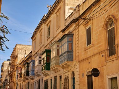 Malta 'nın Rabat kentindeki tarihi kireçtaşı binasında Gallarija olarak bilinen geleneksel renkli Malta ahşap balkonları. Otantik Akdeniz mimarisi.