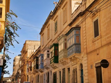 Malta 'nın Rabat kentindeki tarihi kireçtaşı binasında Gallarija olarak bilinen geleneksel renkli Malta ahşap balkonları. Otantik Akdeniz mimarisi.