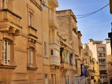 Malta 'da Gallarija olarak bilinen klasik yeşil, kapalı ahşap balkonlu Malta kireçtaşı ev cephesi. Otantik Akdeniz mimarisi.