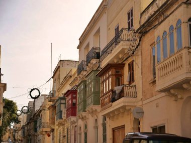 Malta 'daki tarihi kireçtaşı cephesinde Gallarija olarak bilinen geleneksel renkli Malta ahşap balkonları. Otantik Akdeniz sokak manzaralı mimarisi