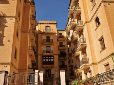 Malta kireçtaşı balkonlu ve Sliema, Malta 'da geleneksel ahşap galerili binalar. Mavi gökyüzü altında Akdeniz kentsel mimarisi.