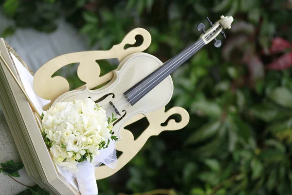 Bouquet da sposa e violino su un supporto contro verdi — Foto Stock