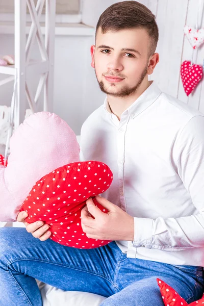 Cara bonito vestido com camisa branca e jeans sentado no cou — Fotografia de Stock