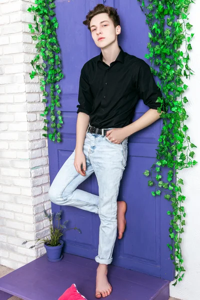 Stilig kille klädd i svart tröja och jeans poserar — Stockfoto