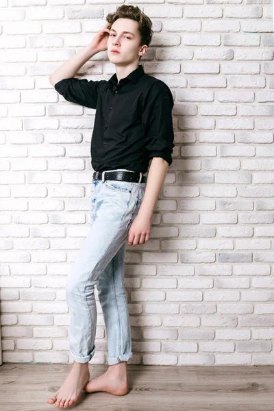 Handsome guy dressed in black shirt and jeans posing — Stock Photo, Image