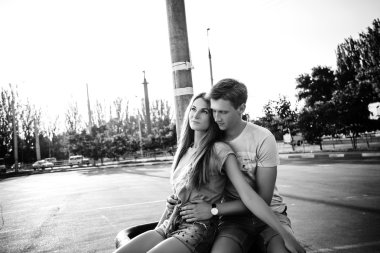 gün batımında sokakta oturan sevgi dolu bir çift. Siyah ve whi