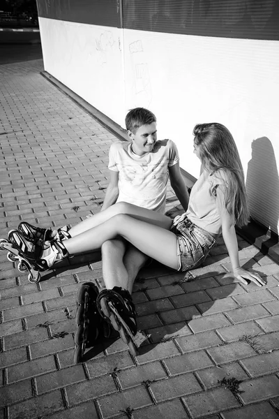 Couple sitting on the curb on a street — Stock Photo, Image