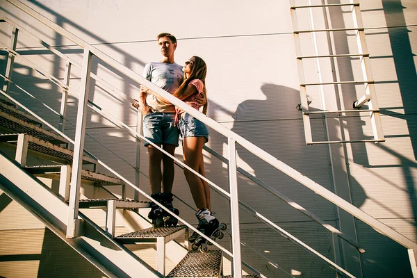 Pareja enamorada en los rodillos cerca de las escaleras en la calle — Foto de Stock