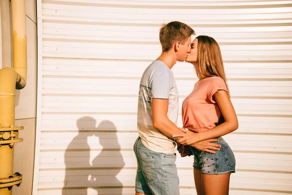 Casal apaixonado nos rolos perto da parede branca na rua — Fotografia de Stock