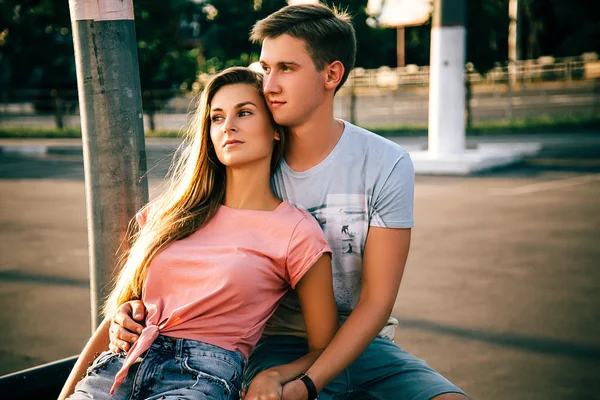 Casal amoroso sentado na rua no pôr do sol — Fotografia de Stock