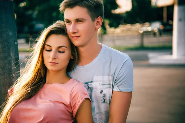 Milující dvojice sedícího na ulici při západu slunce — Stock fotografie