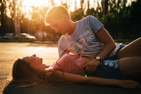 Pareja cariñosa tumbada en el asfalto — Foto de Stock