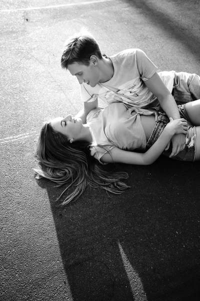 Loving couple lying on the asphalt. Black and white — Stock Photo, Image