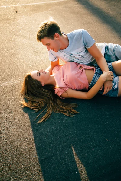 Milující pár ležící na asfalt — Stock fotografie