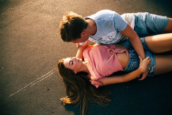 Verliefde paar liggend op het asfalt — Stockfoto