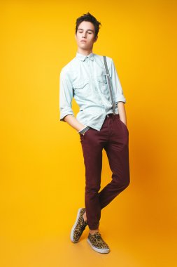 Sarı zemin üzerine genç adam stüdyo fotoğrafı 